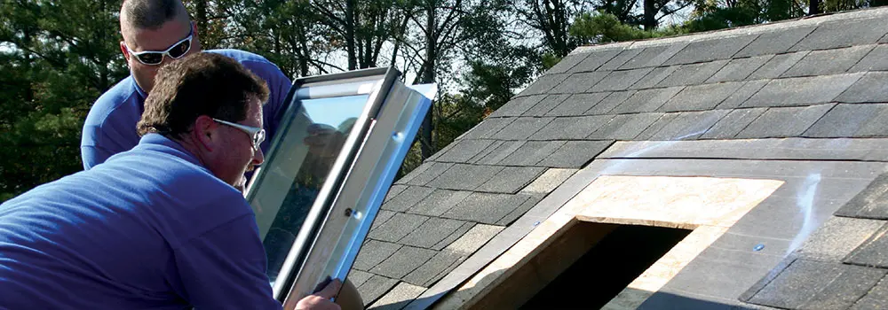 Crew installing Velux brand skylights on roof